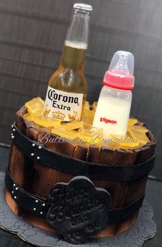 a cake made to look like a barrel with two bottles on top and an empty bottle in the middle