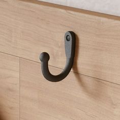 a close up of a door handle on a wooden cabinet