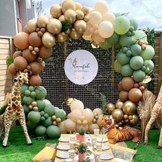 a giraffe and other animals are on display at a table with many balloons