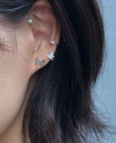 a close up of a person's ear with two piercings on top of it