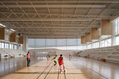 some people are playing tennis in an empty gym