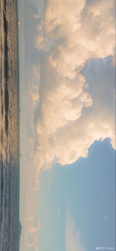 the sky is filled with white clouds over the ocean and beach area, as seen from an airplane