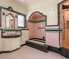 a bathroom with pink and black tiles on the walls, two sinks, an open shower stall and a walk in tub