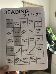 a hand holding up a notebook with writing on it and the words reading bingo written in black ink