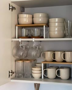 the shelves are filled with dishes and cups