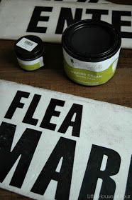 a sign that says flea marq next to some other items on a table top