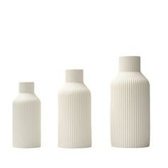 three white vases sitting next to each other