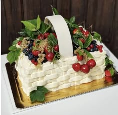 a cake with berries, strawberries and leaves on it