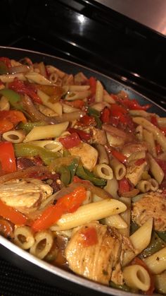 a pan filled with pasta and vegetables on top of a stove