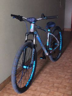 a blue and black bike parked in a room with tile flooring on the ground