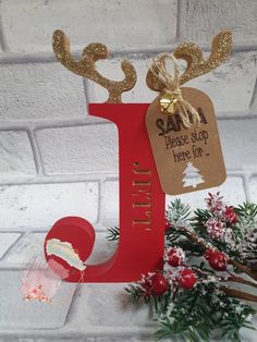 a red letter with gold glitter antlers and a tag that says, please stop here on it