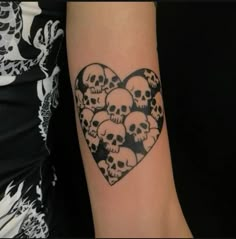 a heart shaped tattoo with skulls on it