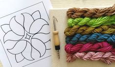 a bunch of yarn sitting on top of a table next to a crochet hook