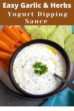 a plate with carrots, cucumbers and dip