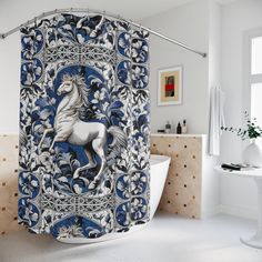 a blue and white shower curtain with a horse on it's back in a bathroom