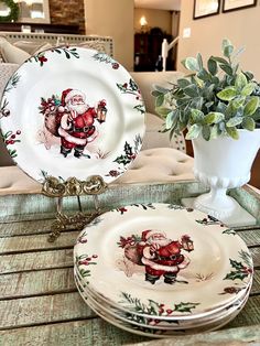 two plates with santa claus on them sitting next to a potted plant