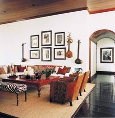 a living room filled with lots of furniture and pictures on the wall above it's coffee table