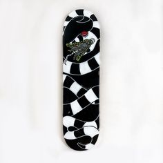 a black and white skateboard with an alligator on it's front end, against a white background