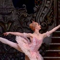 the ballerina is dressed in pink and has her arms stretched out, as if she's dancing