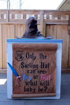 an image of a man sitting on top of a box with a sign that reads, only the sorting hat can see what will baby be?