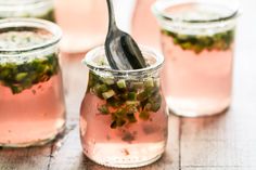 there is a spoon in a jar with pickled vegetables on the table next to it