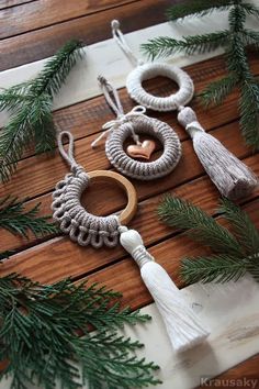 the ornaments are hanging on the wooden floor next to pine cones and fir branches, which have been decorated with white tassels