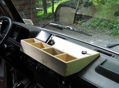 the interior of a car with an open cell phone holder in the dash board area