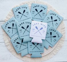 six lake life coasters sitting on top of a white plate with rafters and paddles