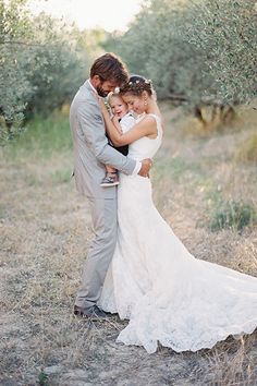 a bride and groom embracing in an olive grove