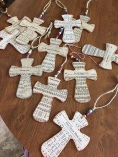 several wooden crosses with sheet music on them sitting on top of a table next to string lights