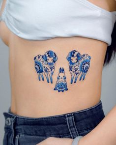 a woman's stomach with three blue elephants on it and an animal in the middle