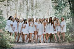 a group of women standing next to each other in white dresses