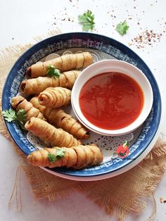 some food on a blue and white plate with dipping sauce