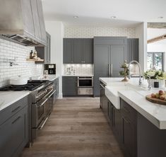 a kitchen with gray cabinets and white counter tops