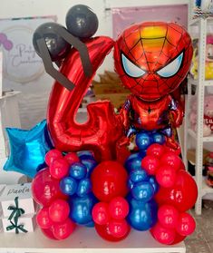 the balloon is shaped like a spider - man and has balloons attached to its head