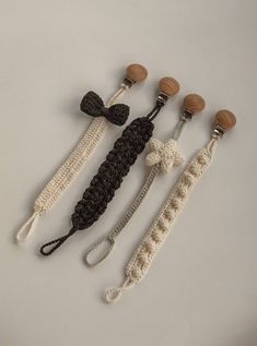 four crocheted items are arranged on a white surface, one is black and the other is brown