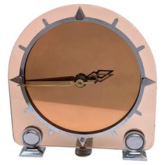 a clock that is sitting on top of a metal stand with two wheels and an arrow in the middle