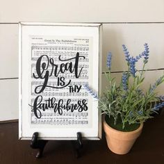 a potted plant sitting on top of a wooden table next to a framed print