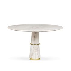 a white marble table with gold trim around the base and an oval shaped center piece