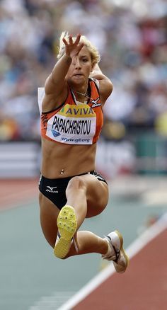 a woman is jumping in the air on a track