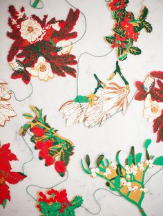 some paper flowers and leaves on a white table top with wires attached to the sides