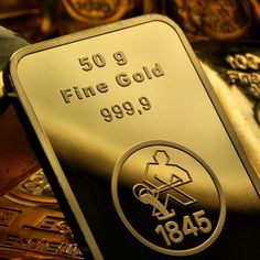 a gold bar sitting on top of a table next to other metal items in front of it