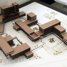 an architectural model of a building on top of blueprints