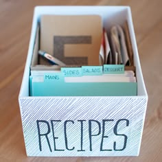 an organized recipe box on a wooden table with the word recipes written in black ink