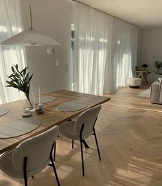 a dining room table with chairs and place settings