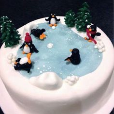 there is a cake decorated with penguins in the water