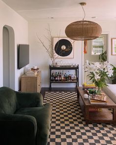 a living room filled with furniture and a checkered flooring pattern on the floor