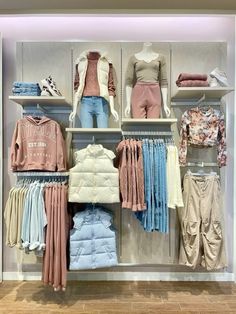 a clothing store display with clothes and jackets on the shelves, including sweaters and pants