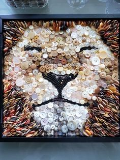 an animal made out of buttons in a black frame