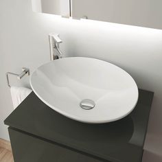 a white bowl sink sitting on top of a black counter